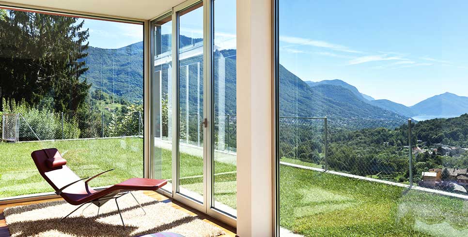 A reclining chair surrounded by wide open windows.