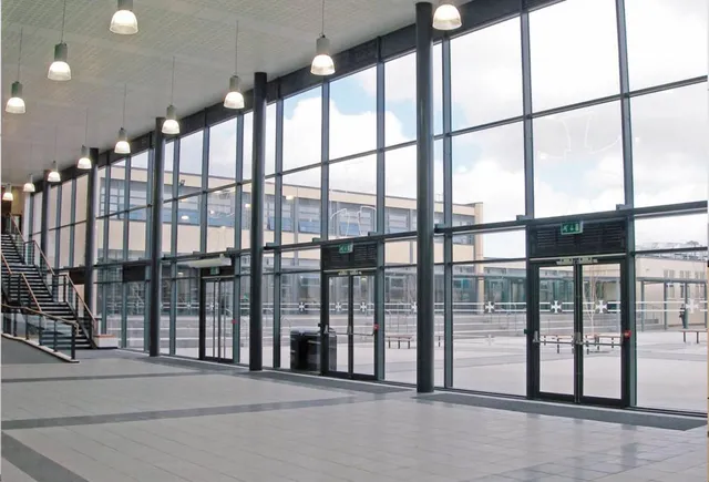 large wall of windows and glass doors of lobby of commercial building